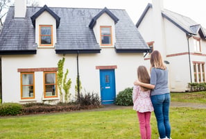 mutter und tochter im rasen stehend vor einem haus